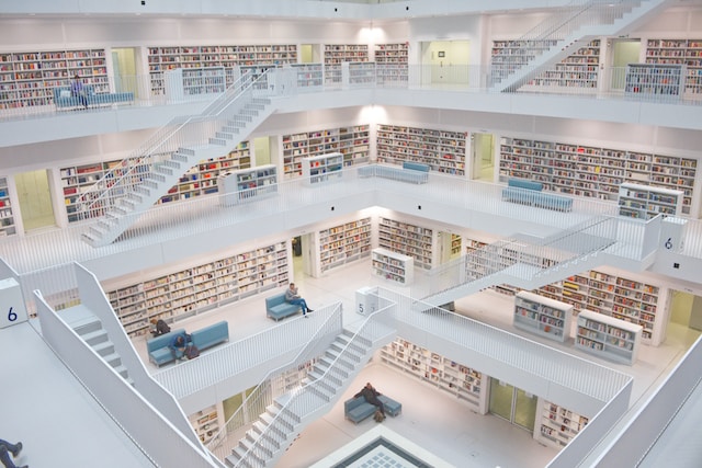 Une grande bibliothèque lumineuse avec des escaliers blancs